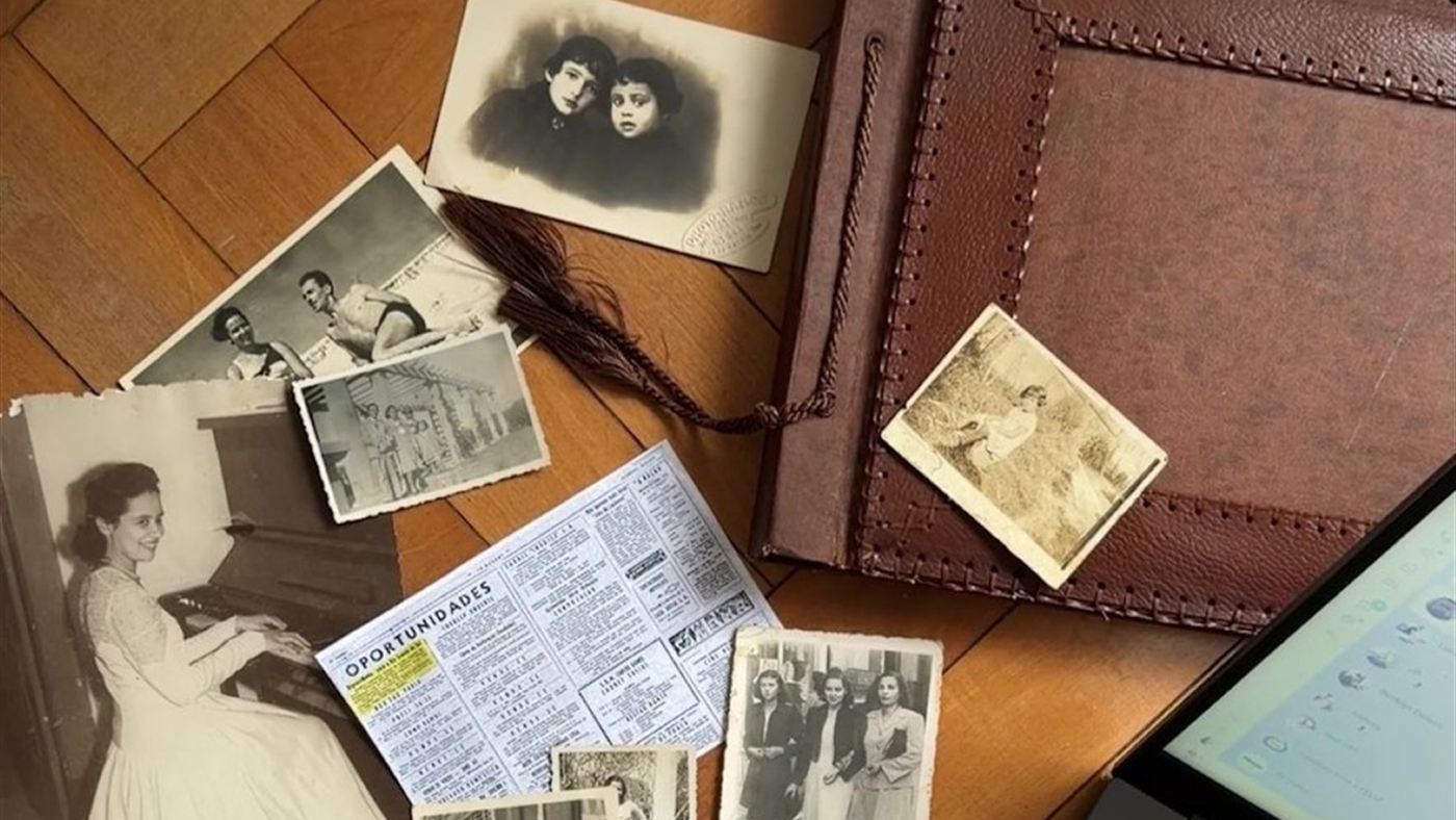 Fotos antigas em preto e branco espalhadas ao lado do álbum de couro comprado em feira