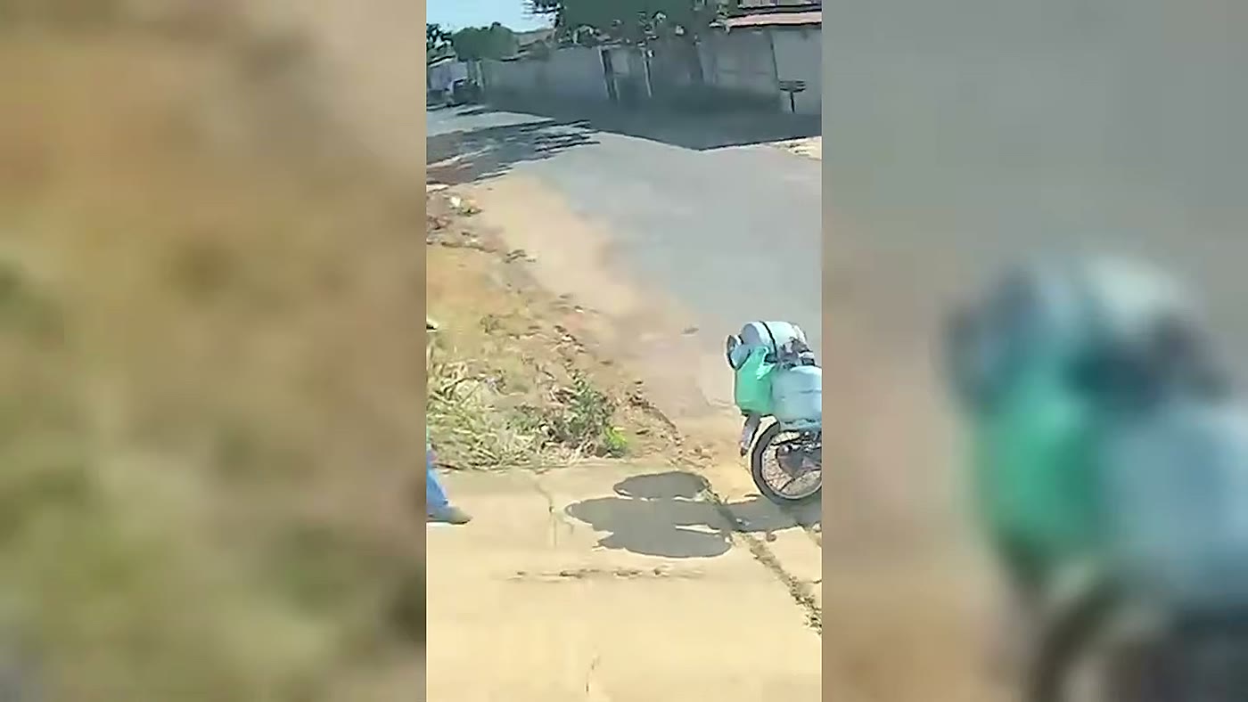 Moto carregada de botijões de gás na rua onde o cachorro furtou a bolsa do entregador em João Pinheiro