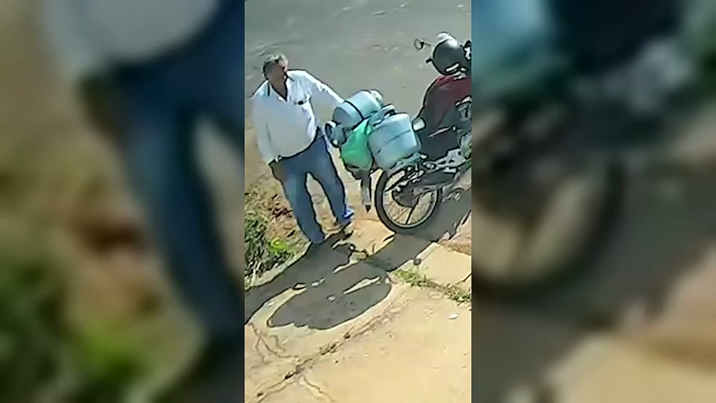 Entregador de gás Milton ao lado da moto minutos depois do cachorro furtar a bolsa em João Pinheiro