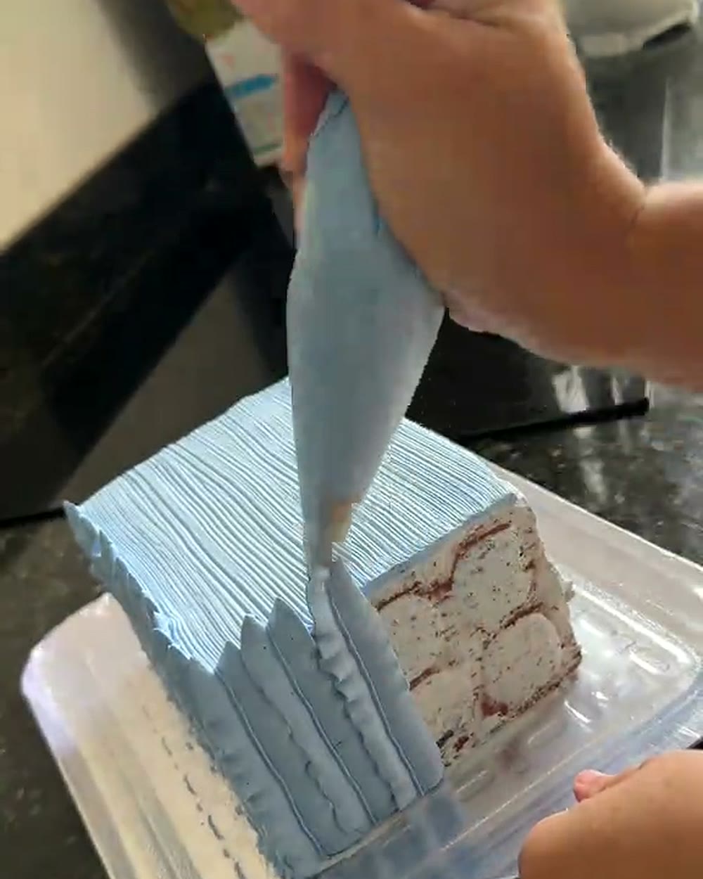 Nathy decorando o tijolo com chantilly para simular um bolo de confeitaria