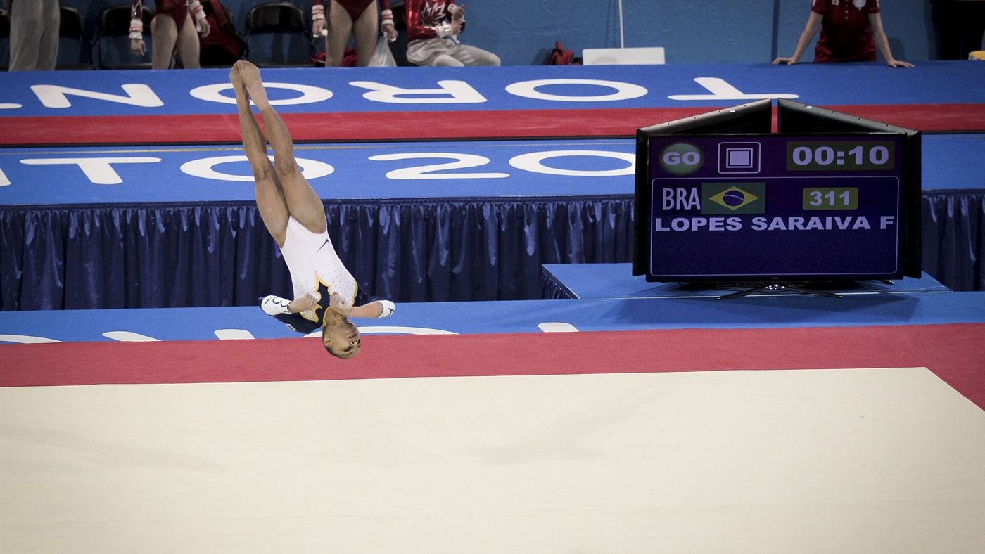 Flávia Saraiva realizando salto mortal durante apresentação no solo em competição de ginástica artística