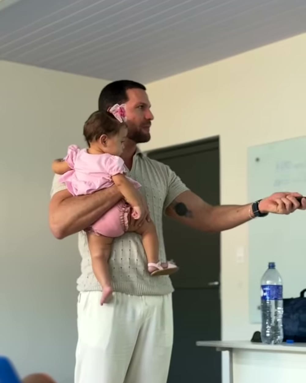 Professor com bebê no colo em pé na sala de aula da Uespi, no Piauí