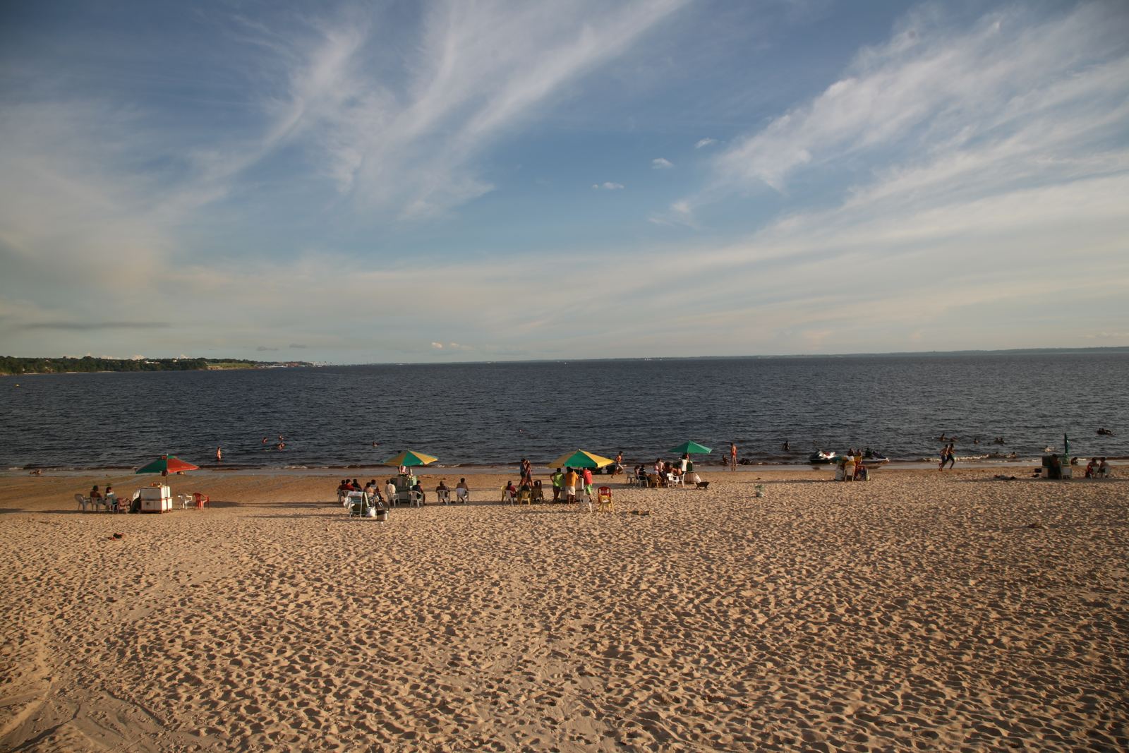 Praia de areia exposta às margens do rio Negro em Manaus, com o rio ao fundo