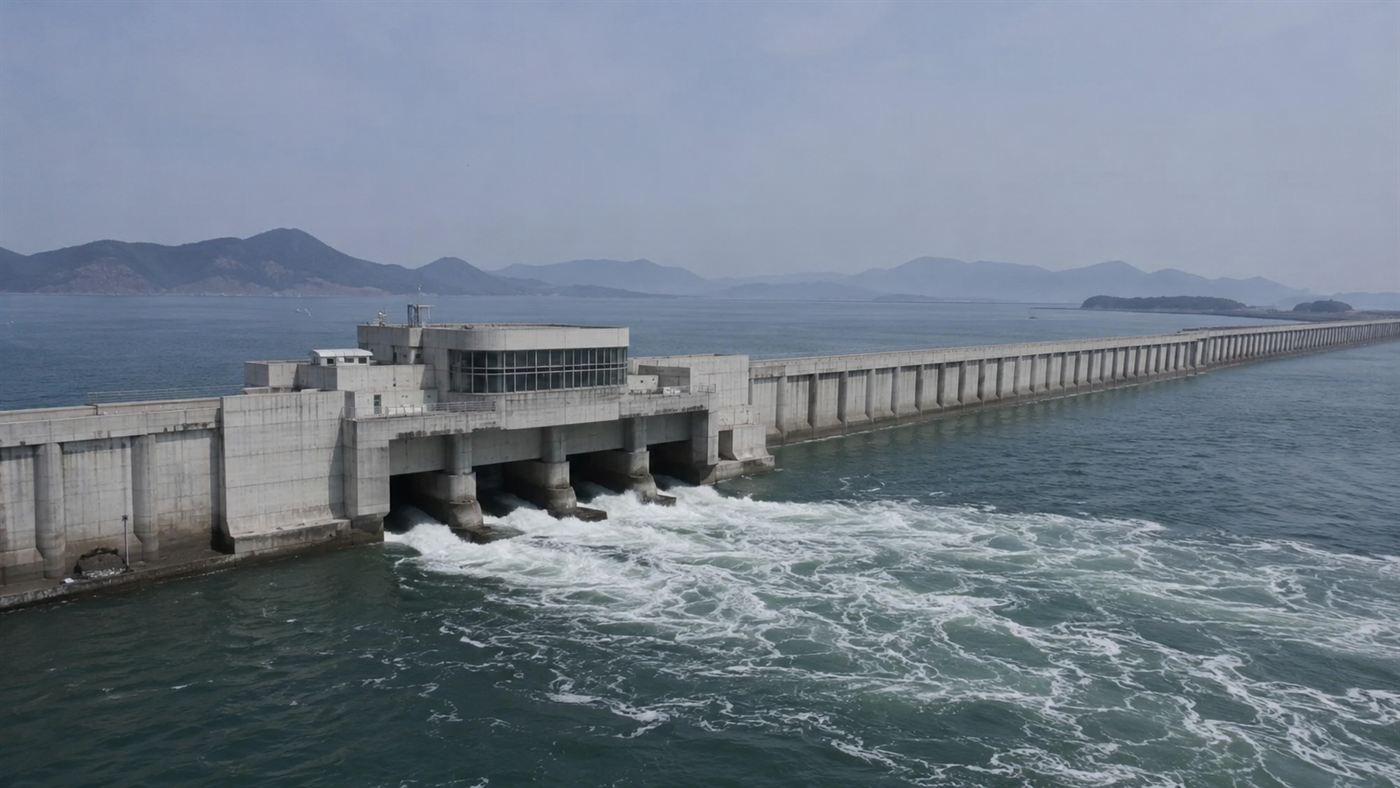 The long concrete seawall and turbine powerhouse of the Sihwa Lake tidal power station with seawater rushing through