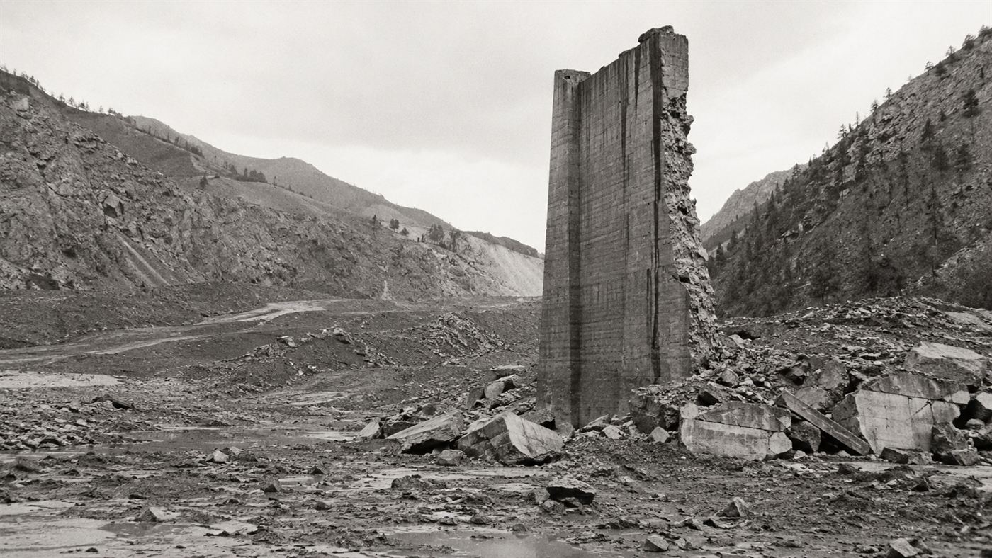 The lone surviving concrete monolith of the St. Francis Dam standing in a wrecked canyon after the 1928 collapse