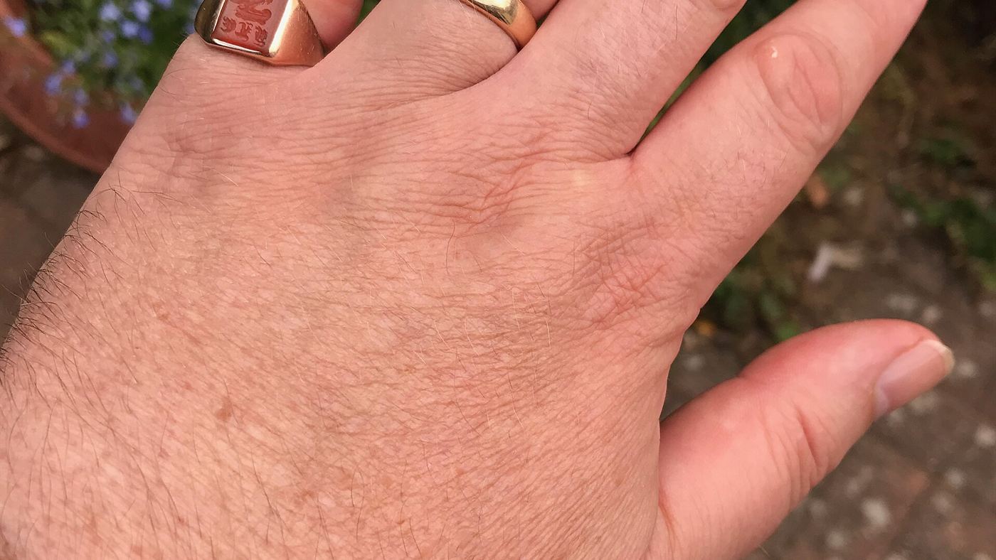 Mão com alianças, símbolo do compromisso celebrado no casamento coletivo de trisais
