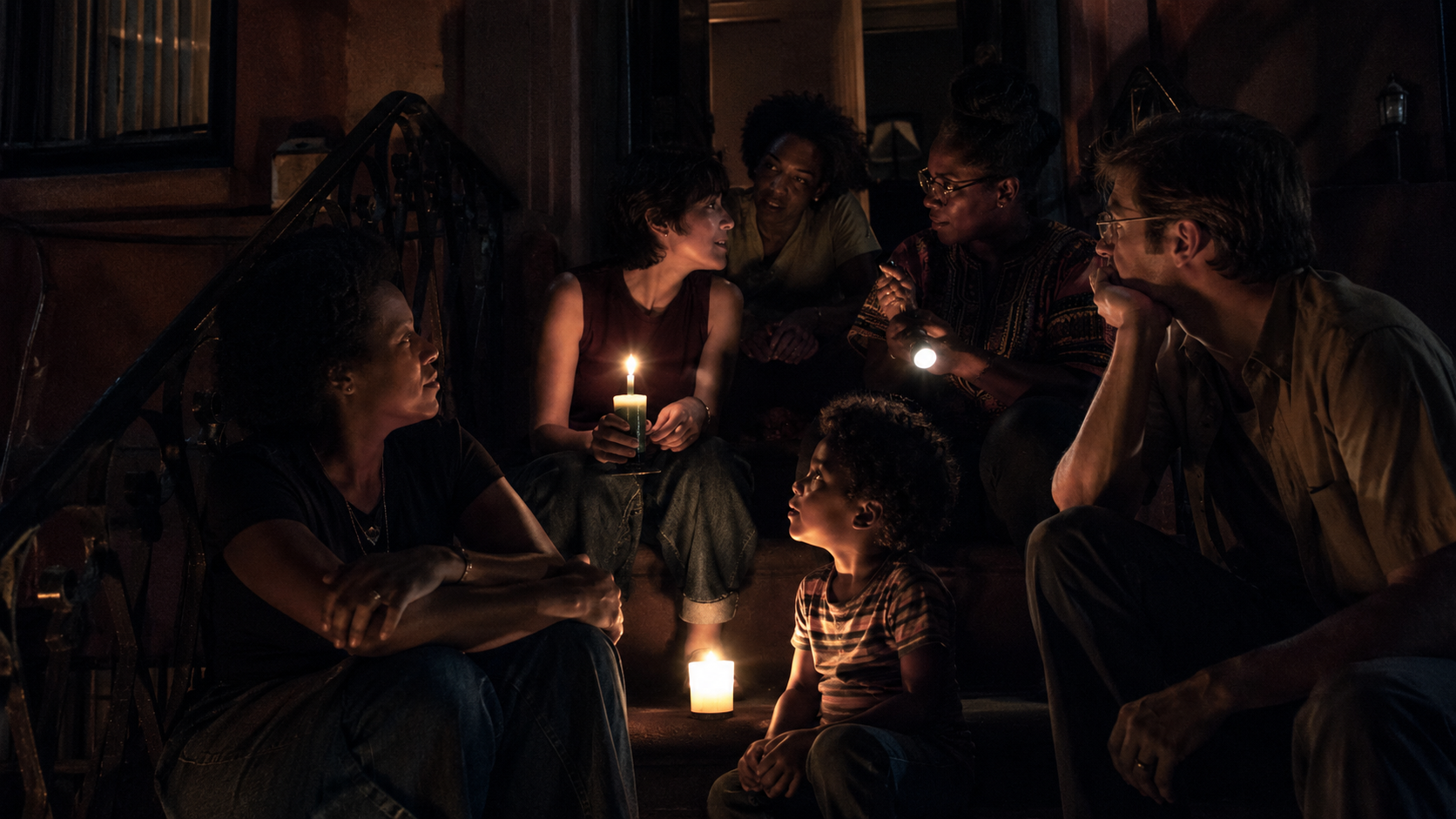 Neighbours gathered by candlelight on a stoop during the 1977 New York City blackout