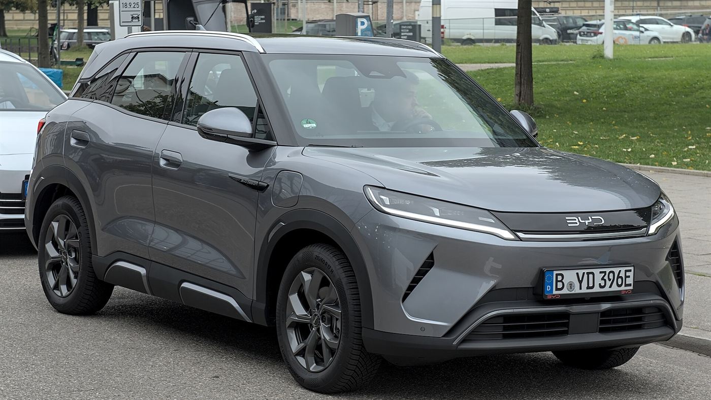 BYD Atto 2 na cor cinza em movimento, com motorista ao volante, visto de frente em ângulo lateral
