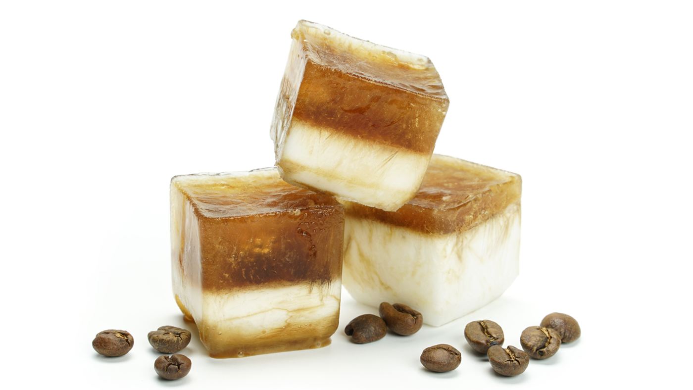 Congelar café em forminhas de gelo: cubos de café com camada de creme de leite e grãos torrados ao redor