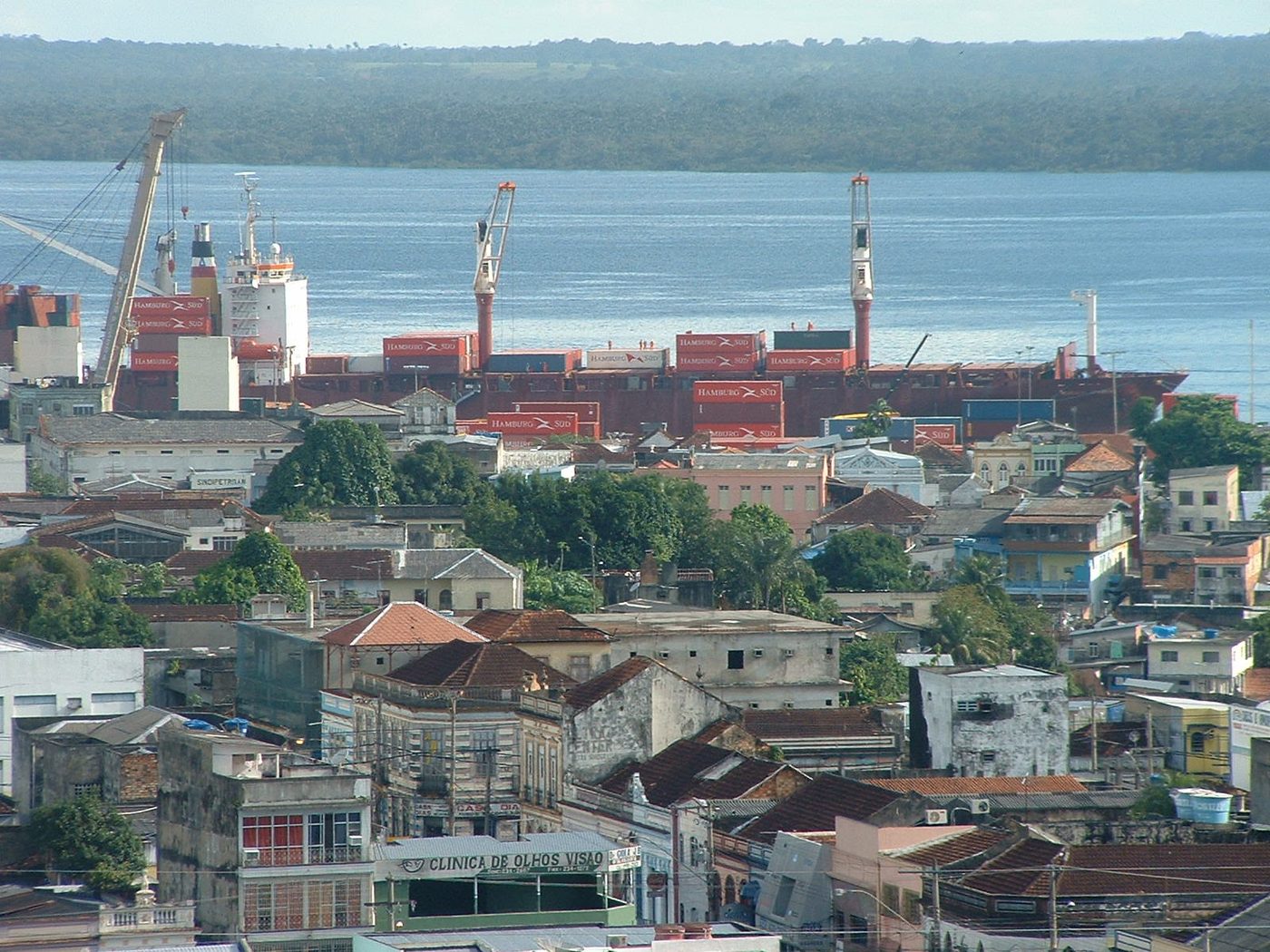 Vista do porto de Manaus, com navio de contêineres, guindastes e o bairro histórico às margens do rio Negro