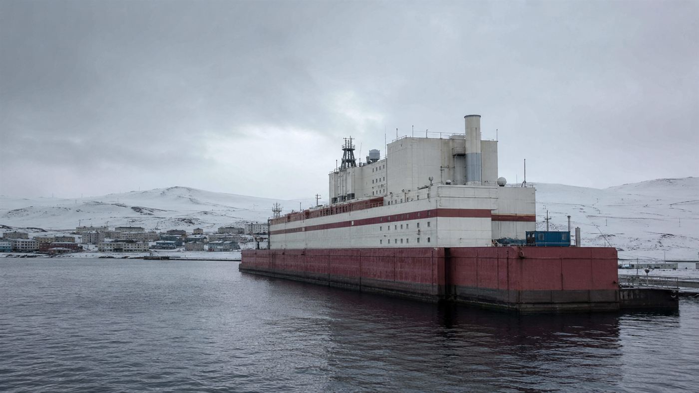 The Akademik Lomonosov floating nuclear power plant, a barge moored at a snowy Arctic port town