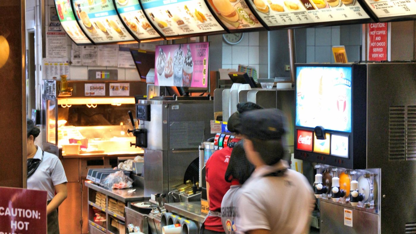 Funcionários atendendo no balcão de um McDonald's, mesma função que Eric Edwards exerce