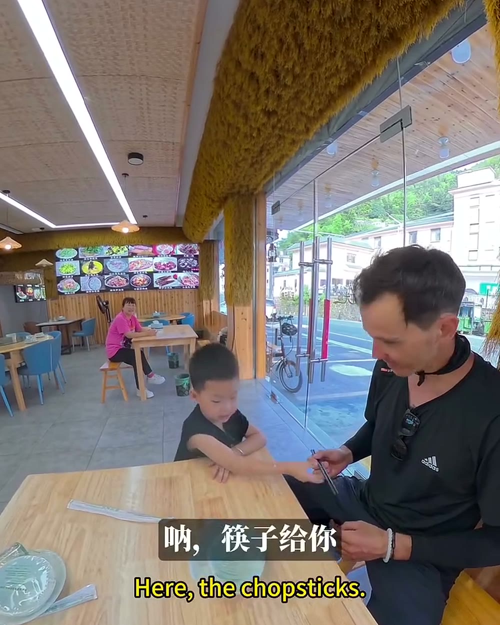 Menino convida ciclista para entrar no restaurante da família na China