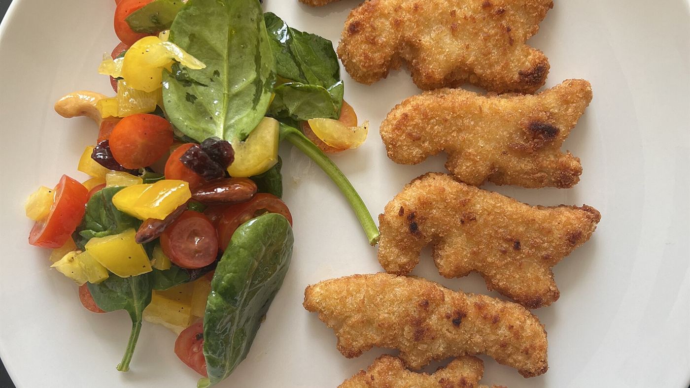 Nugget caseiro em formato de dinossauro servido com salada, receita que troca o empanado industrializado