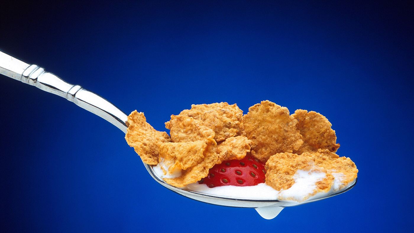 Colher com cornflakes e leite, cereal usado como empanado caseiro no lugar da farinha industrial do nugget