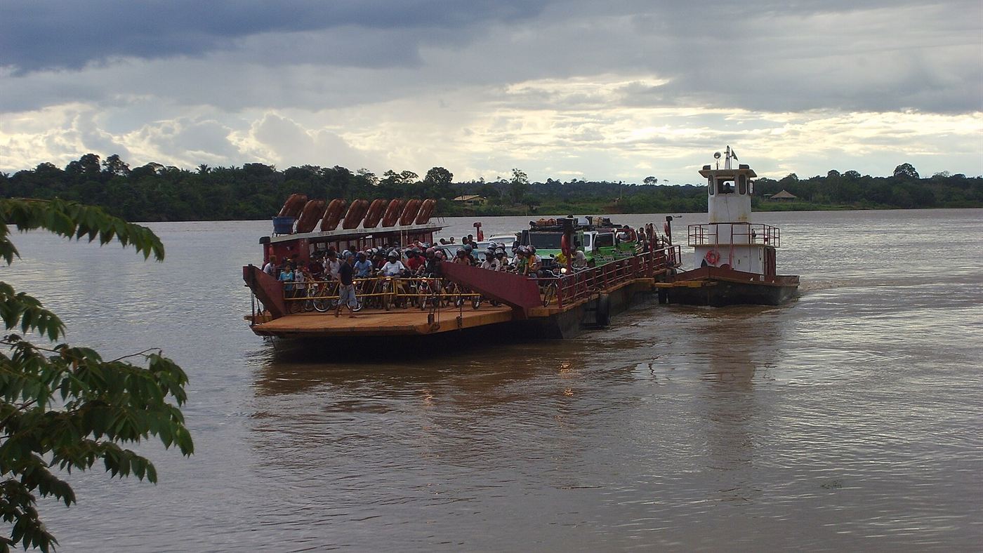 Balsa lotada de passageiros, bicicletas e motos atravessando o rio Madeira perto de Porto Velho