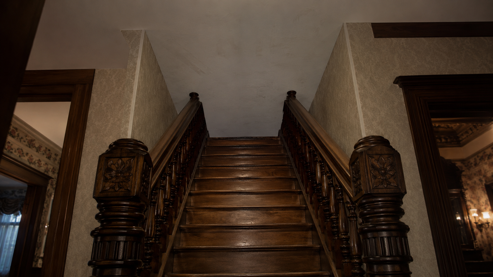 A wooden staircase inside the Winchester Mystery House that climbs straight into a blank ceiling