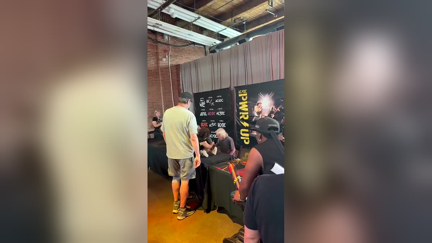 Fãs acompanham integrantes do AC/DC autografando itens no pop-up de Toronto