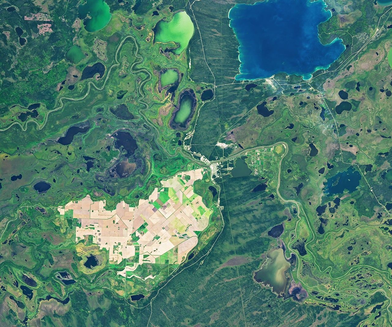 Imagem de satélite de 21 de setembro de 2026 em quadro aberto mostra a ilha de campos, a cidade de The Pas, o rio e um grande lago azul no delta do Saskatchewan