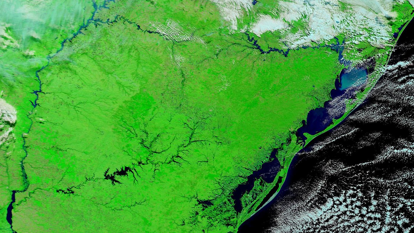 Imagem de satélite do Sul do Brasil mostrando rios cheios e áreas alagadas próximas ao litoral