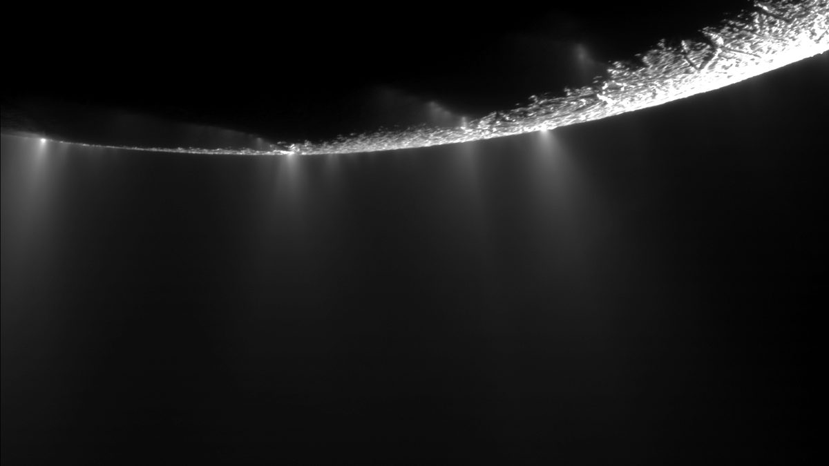 Jatos de gelo saindo da superfície de Encélado, lua de Saturno, em imagem da Cassini contra o fundo escuro