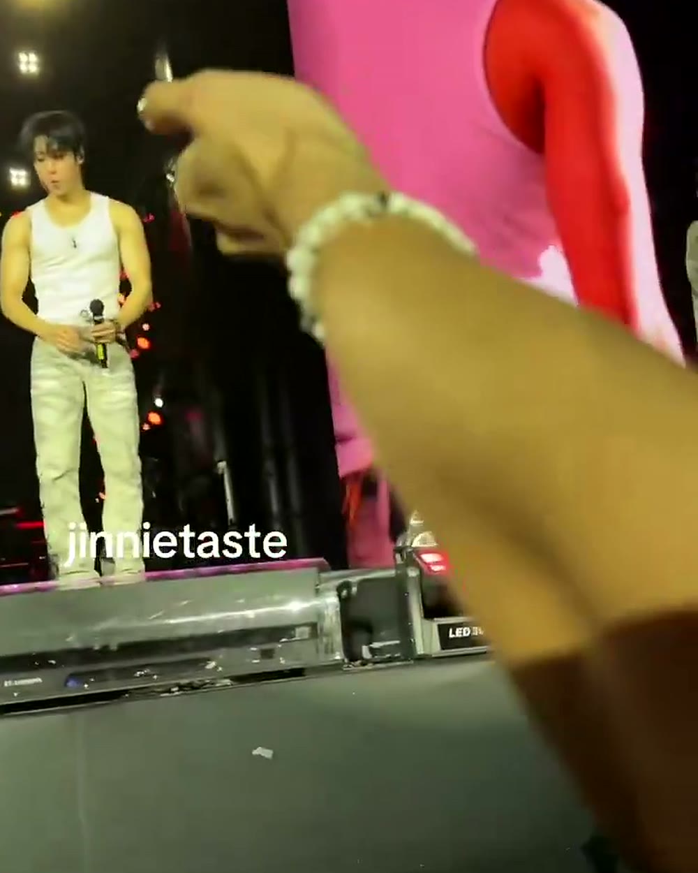 Jisung no palco do show, com a segurança visível logo abaixo, momentos antes do gesto da toalha