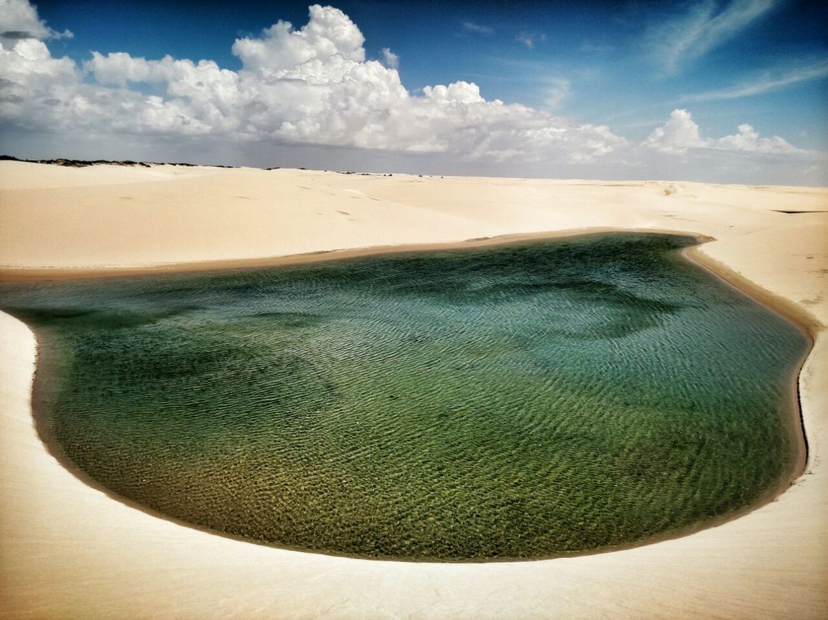 Lagoa verde de água doce entre as dunas de areia do Parque Nacional dos Lençóis Maranhenses.