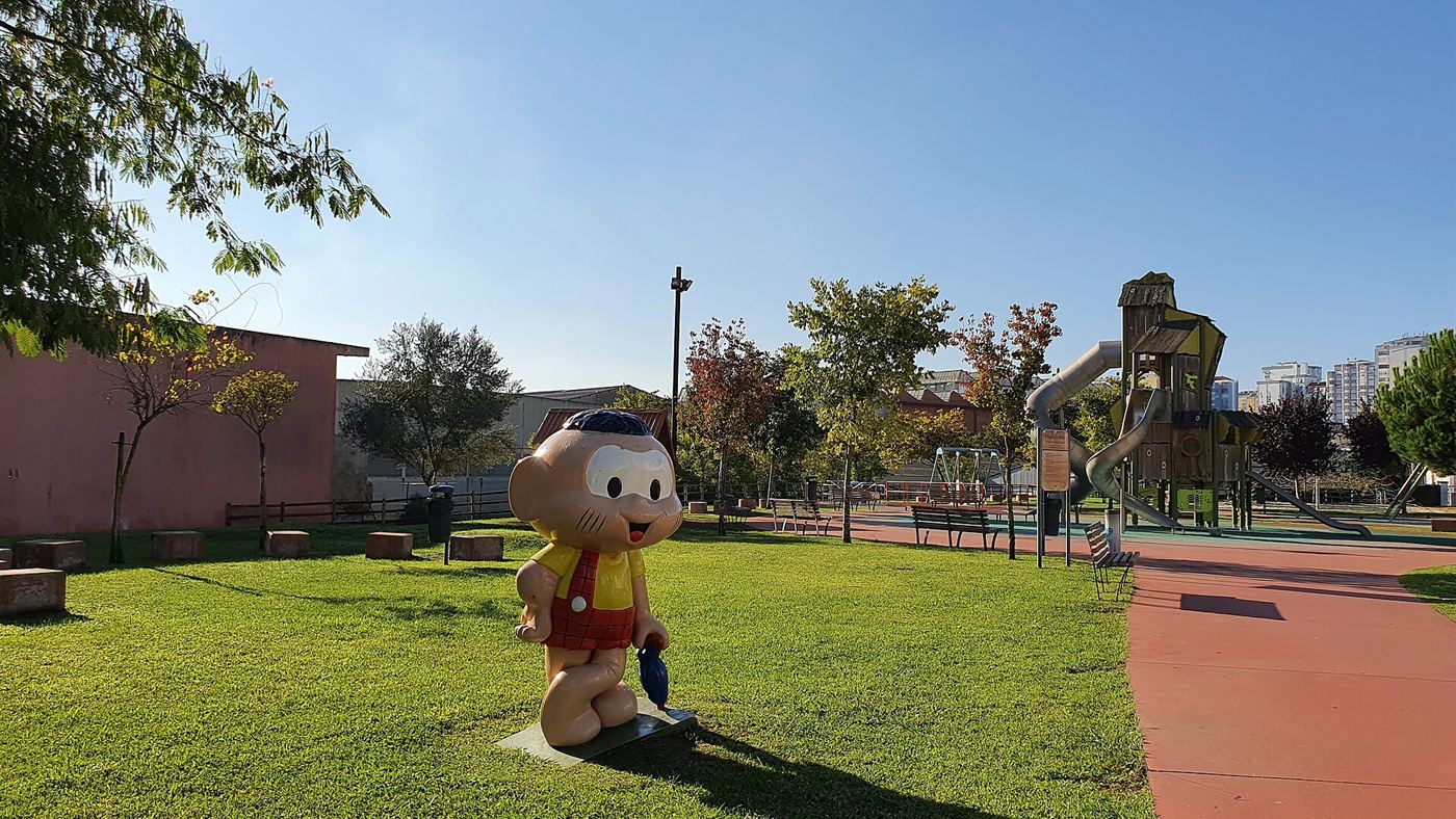 Estátua de personagem da Turma da Mônica em área de playground de parque público
