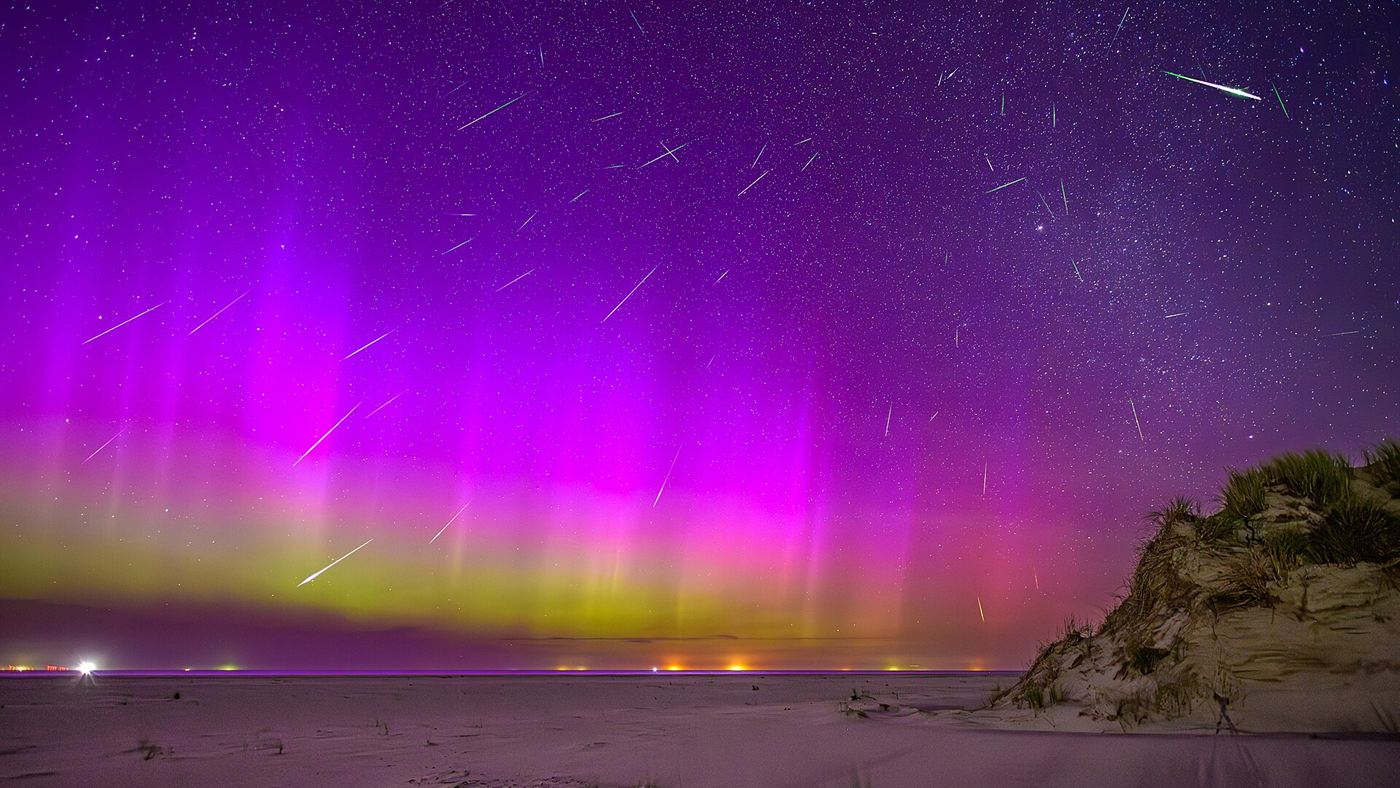 Céu noturno com dezenas de riscos de meteoros durante uma chuva de estrelas cadentes.