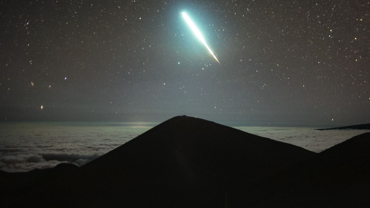 diferença entre meteoro e meteorito: bólido riscando o céu estrelado acima de um mar de nuvens.