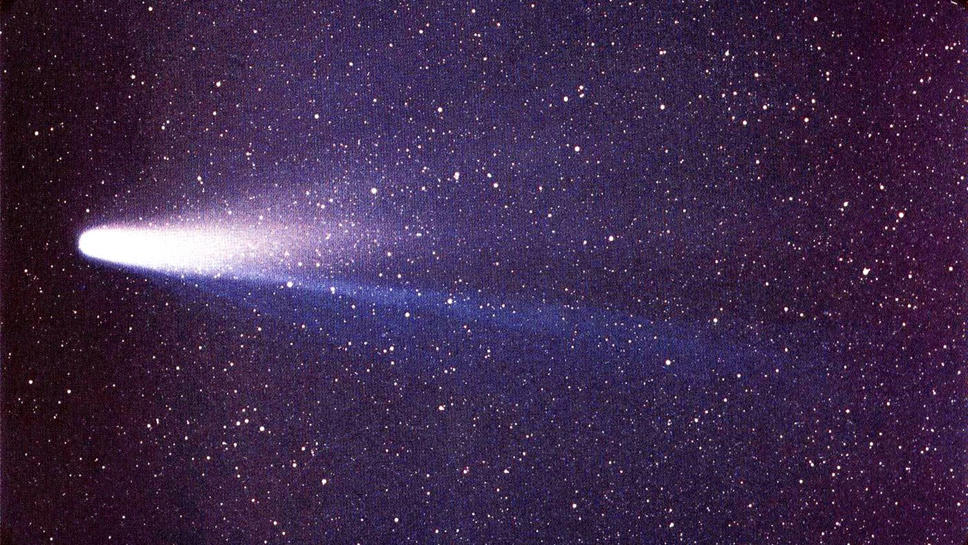 cometa Halley fotografado em 1986, com o núcleo brilhante e a cauda de poeira e gás se estendendo pelo céu estrelado.