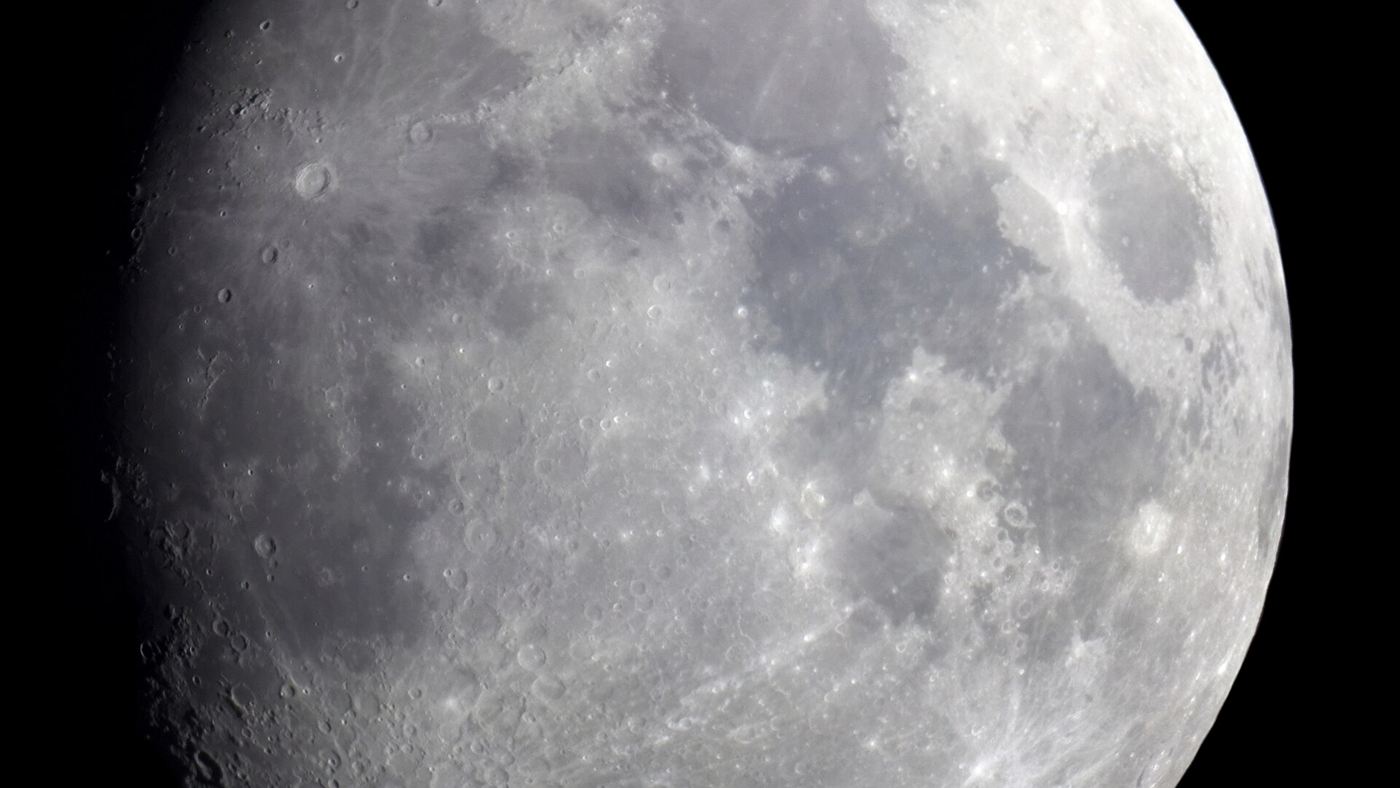 fase crescente gibosa da Lua fotografada em close, com crateras visíveis na superfície iluminada.