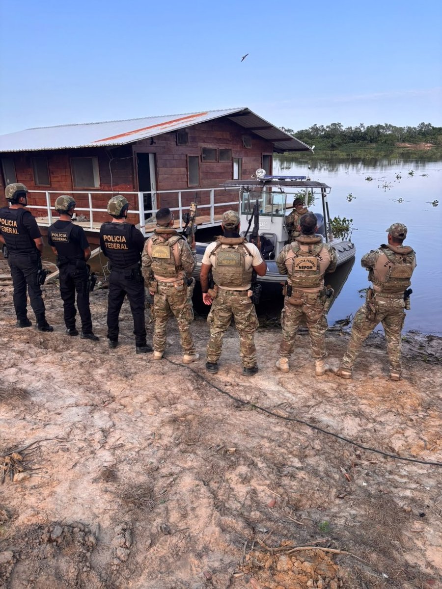 Policiais federais em frente a uma casa flutuante e a uma lancha às margens de um rio no Pantanal durante a Operação Pecus Exploratio