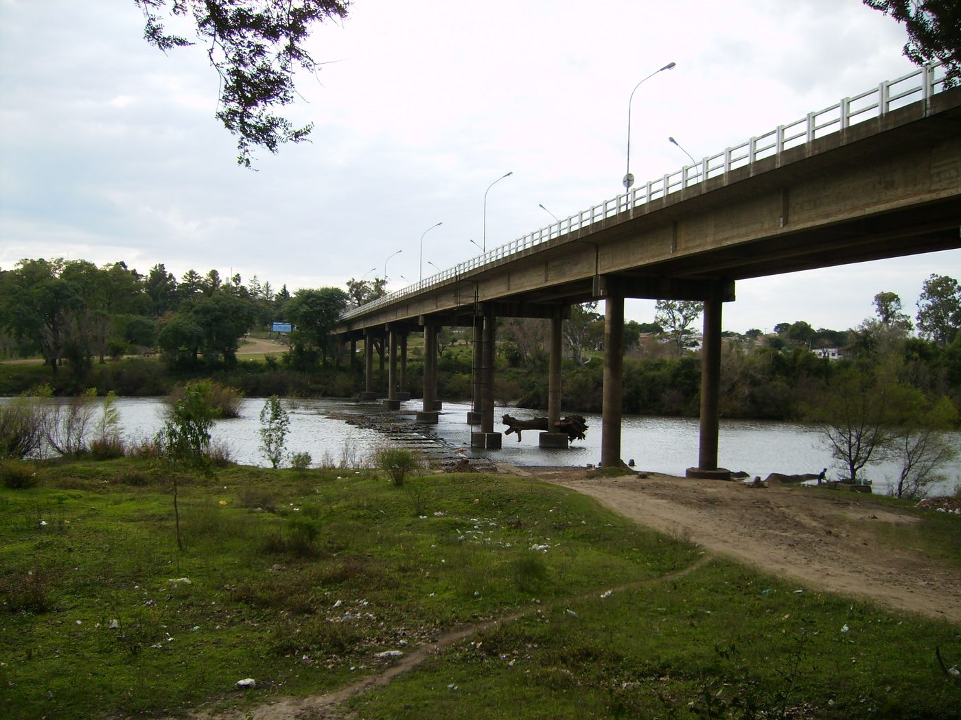 Imagem de arquivo de 2007: a ponte da Concórdia vista de baixo, com os pilares de concreto num rio raso e pedras aparecendo na água