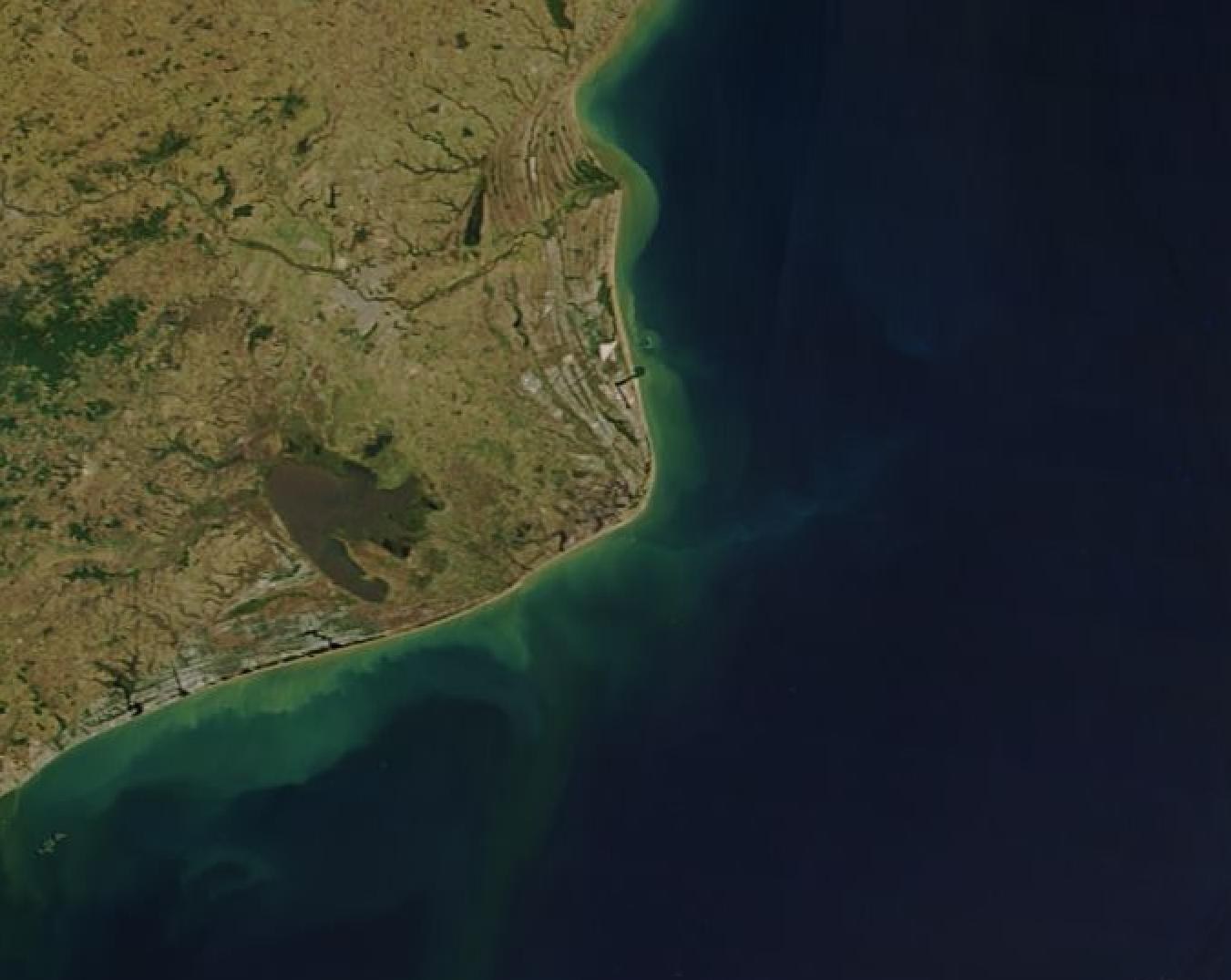 Imagem de satélite do Cabo de São Tomé, no norte fluminense, com a costa em curva e o mar escuro, ponto que marca o limite norte do defeso
