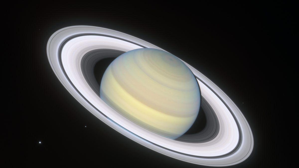 Saturno e seus anéis fotografados pelo telescópio espacial Hubble em 2019, com pequenos pontos de luz que são luas