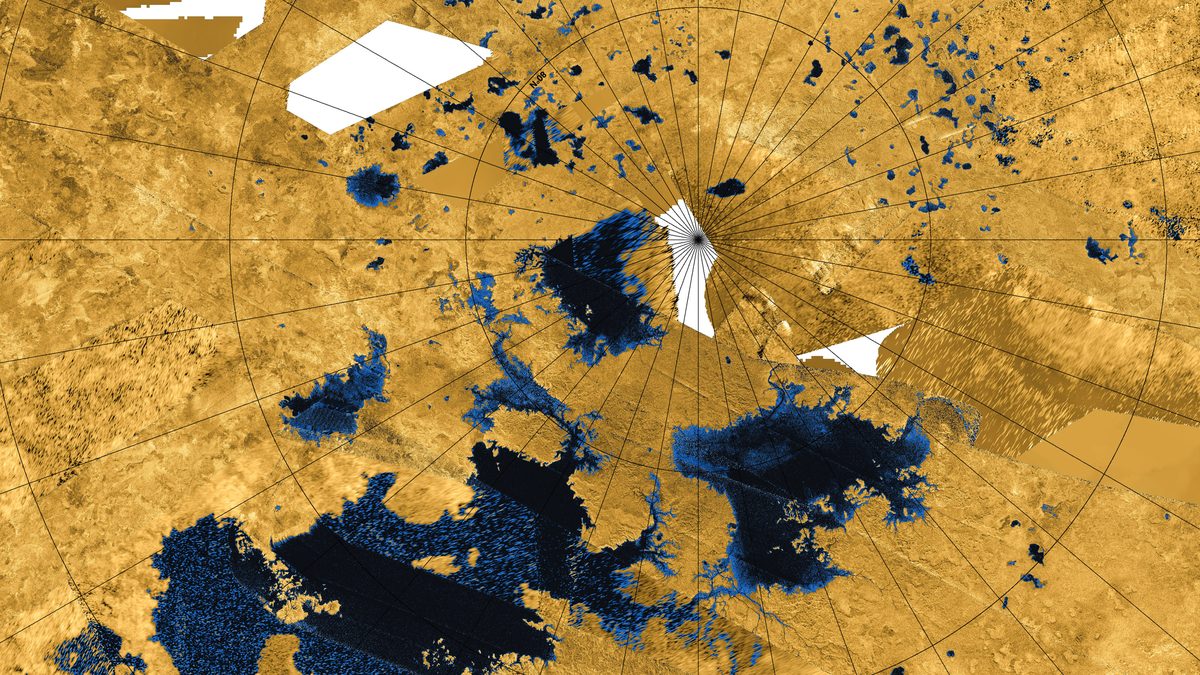 Mosaico de radar colorido do norte de Titã, com lagos e mares em azul e preto sobre terreno amarelo