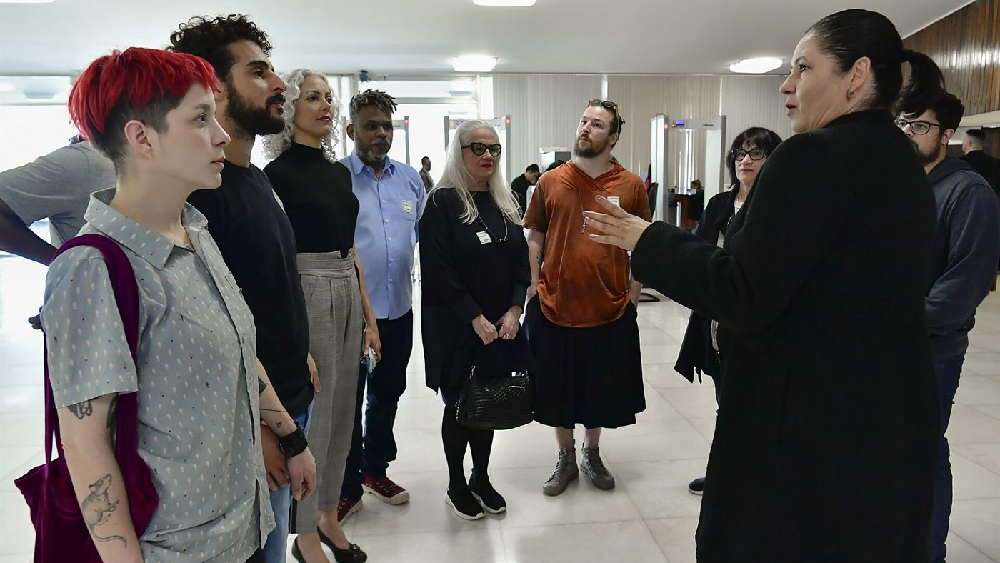 Vera Holtz conversa com grupo de pessoas em ambiente público