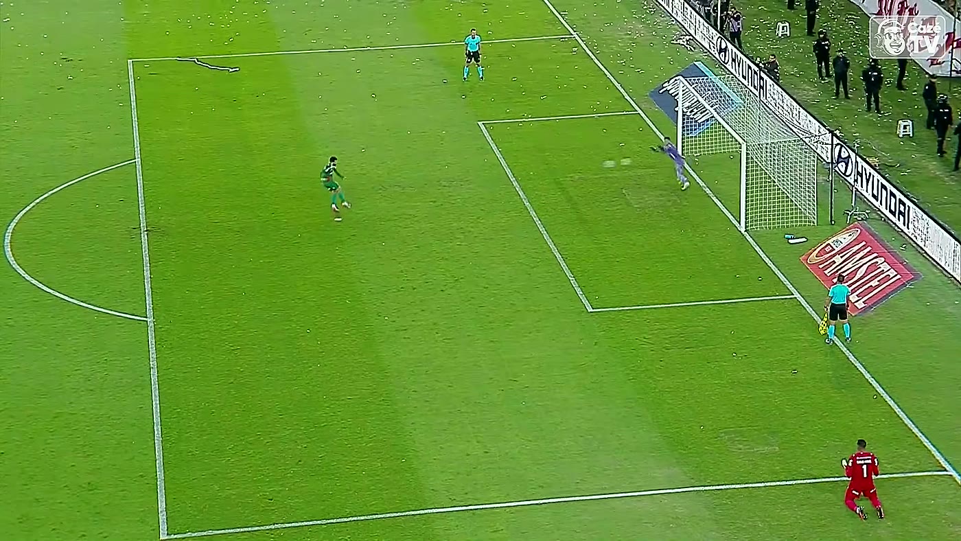 Jogador do Palmeiras bate pênalti enquanto o goleiro da LDU pula para o lado errado