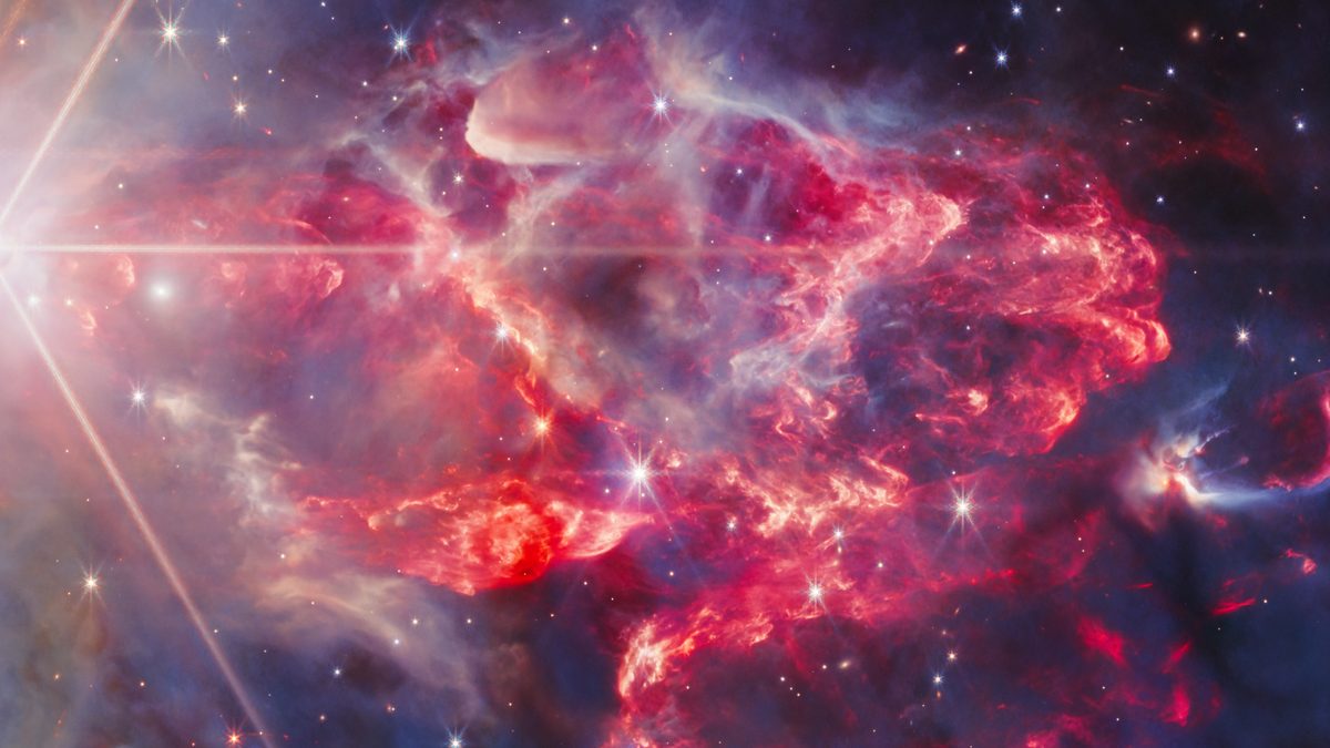 Região vermelha da nebulosa NGC 7129 vista pelo Webb, com jatos de protoestrelas que se sobrepõem e formam um emaranhado de filamentos